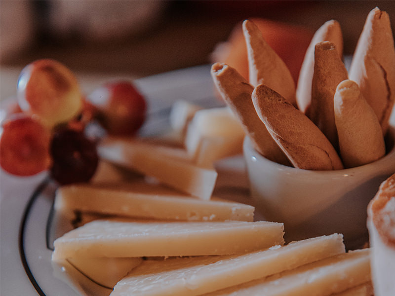 Sliced aged Manchego served with quince jelly, grapes, picos and bread