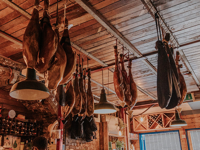Warm wooden bar with jamón hanging above